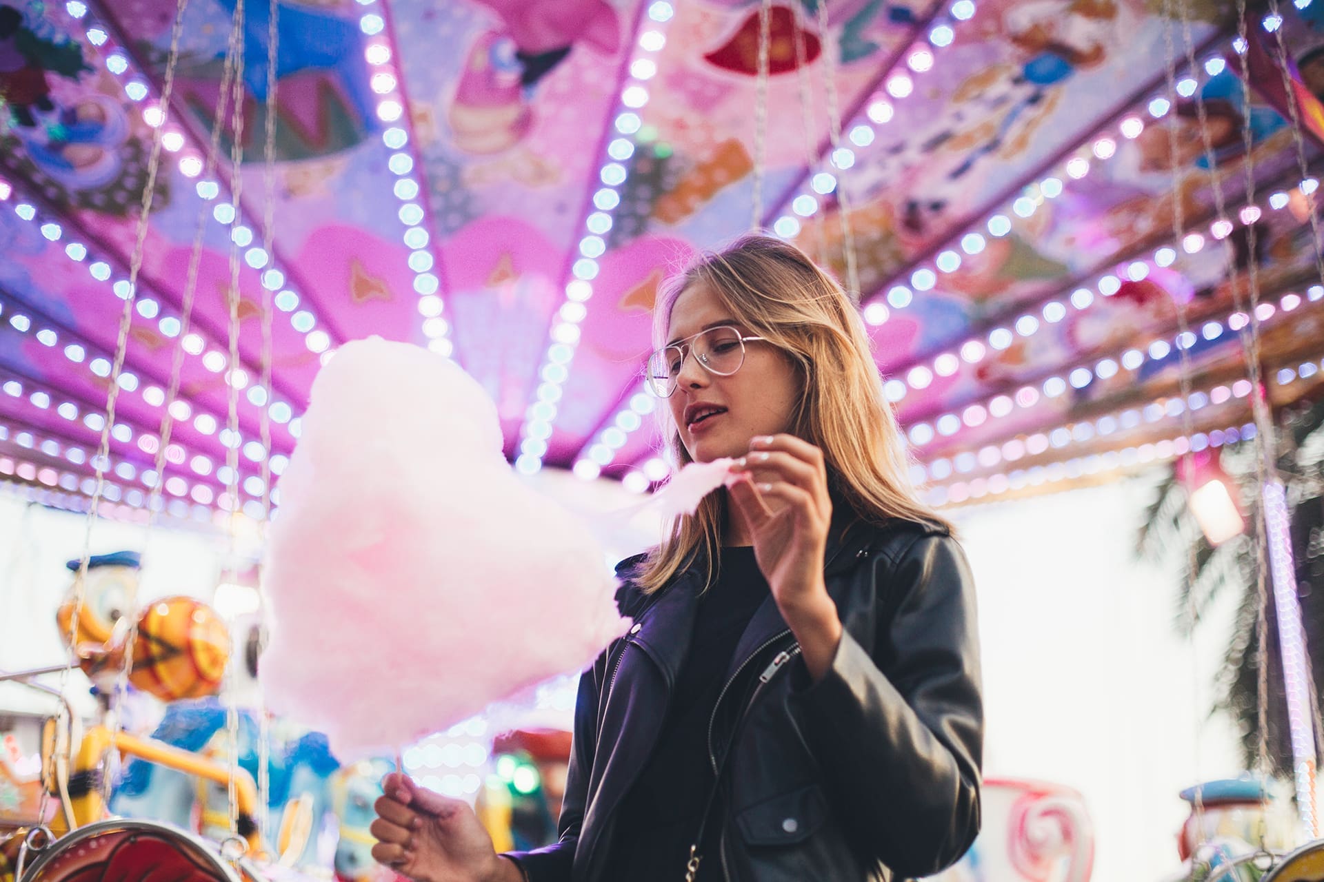 girl at carnival eating cotton candy